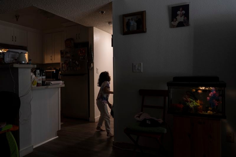 Rubie Caceres, a granddaughter of Marina Maalouf, a longtime resident of Hillside Villa who participated in protests after rents doubled in 2019, enters a bedroom in her apartment in Los Angeles, Tuesday, Oct. 1, 2024. (AP Photo/Jae C. Hong)