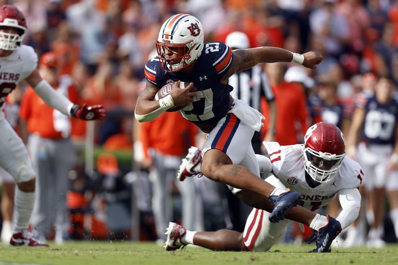 Auburn running back Jarquez Hunter (27) carries the ball as Oklahoma linebacker Kobie McKinzie (11) defends during the first half of an NCAA college football game, Saturday, Sept. 28, 2024, in Auburn, Ala. (AP Photo/Butch Dill)