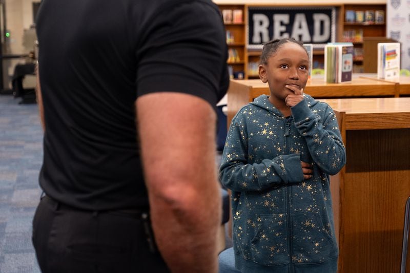 Fourth-grader Noelle Ewuakye thinks about her favorite movie after being asked by Superintendent Chris Ragsdale, who was touring Compton Elementary School in Powder Springs on the first day of class Tuesday, Aug. 1, 2023.   (Ben Gray / Ben@BenGray.com)