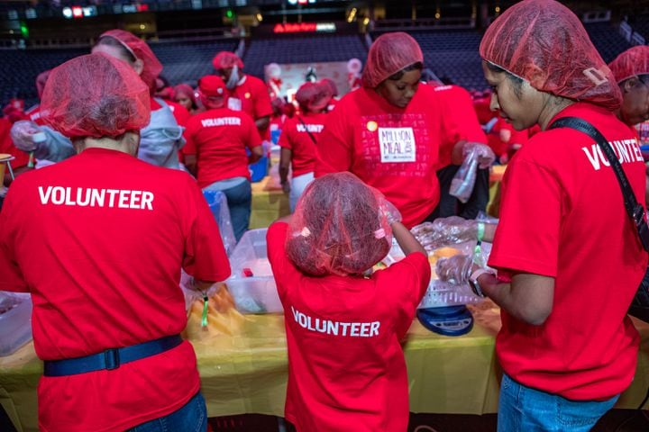  Volunteers of all ages filled up five shifts of more than 1000 people, where they donated their time in 1 1/2-hour blocks to create the food kits.  (Jenni Girtman for The Atlanta Journal-Constitution)