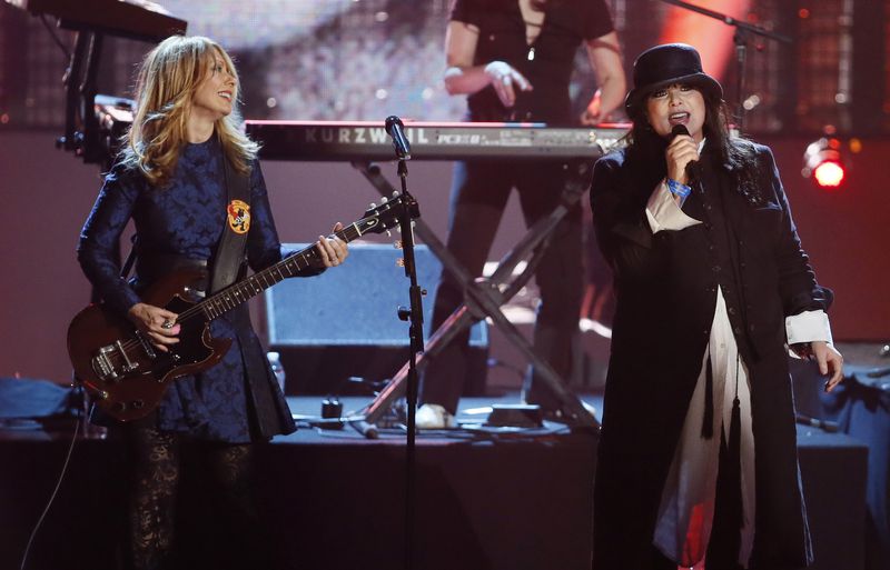 FILE - Nancy Wilson, left, and Ann Wilson, of the band Heart, perform as the band is inducted into the Rock and Roll Hall of Fame during the Rock and Roll Hall of Fame Induction Ceremony in Los Angeles on April 18, 2013. Ann Wilson says she has cancer. The band is postponing the remaining shows on its Royal Flush Tour. (Photo by Danny Moloshok/Invision/AP, File)