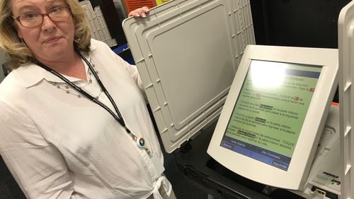In this April 2018 file photo, Gwinnett elections director Lynn Ledford shows off a voting machine’s Spanish-language ballot. TYLER ESTEP / TYLER.ESTEP@AJC.COM