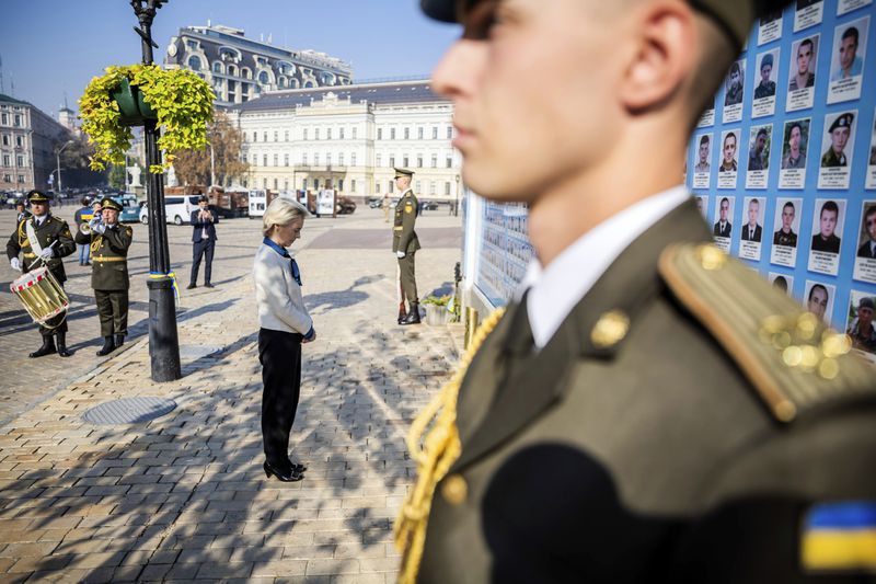 President of the European Commission Ursula von der Leyen, center, visits a wall commemorating the fallen Ukrainian soldiers in the war with Russia, in Kyiv, Ukraine, Friday, Sept. 20, 2024. (Christoph Soeder, Pool via AP)