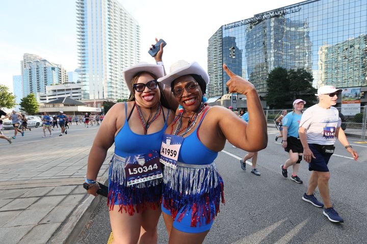 Color coordinated runners pose at the start of the 55th running of the Atlanta Journal-Constitution Peachtree Road Race in Atlanta on Thursday, July 4, 2024.   (Miguel Martinez / AJC)