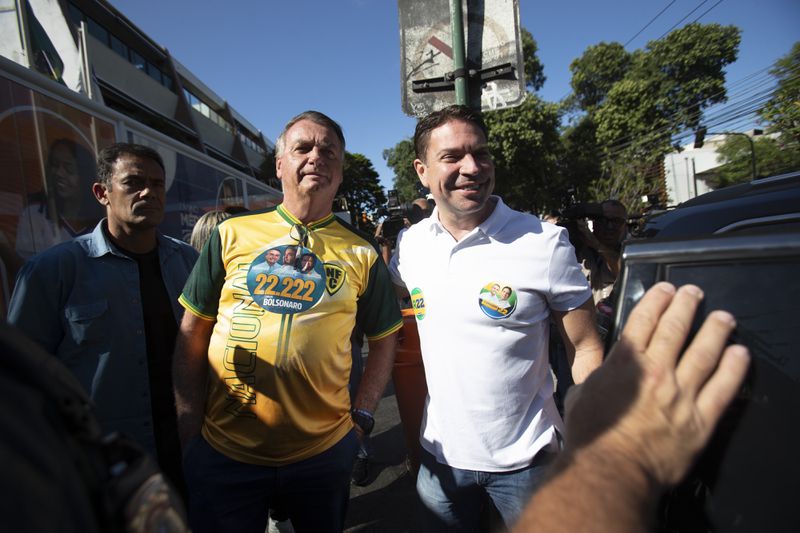 Former President Jair Bolsonaro, center, campaigns with Rio de Janeiro mayoral candidate Alexandre Ramagem, right, of the Liberal Party after voting in the municipal elections, in Rio de Janeiro, Sunday, Oct. 6, 2024. (AP Photo/Bruna Prado)