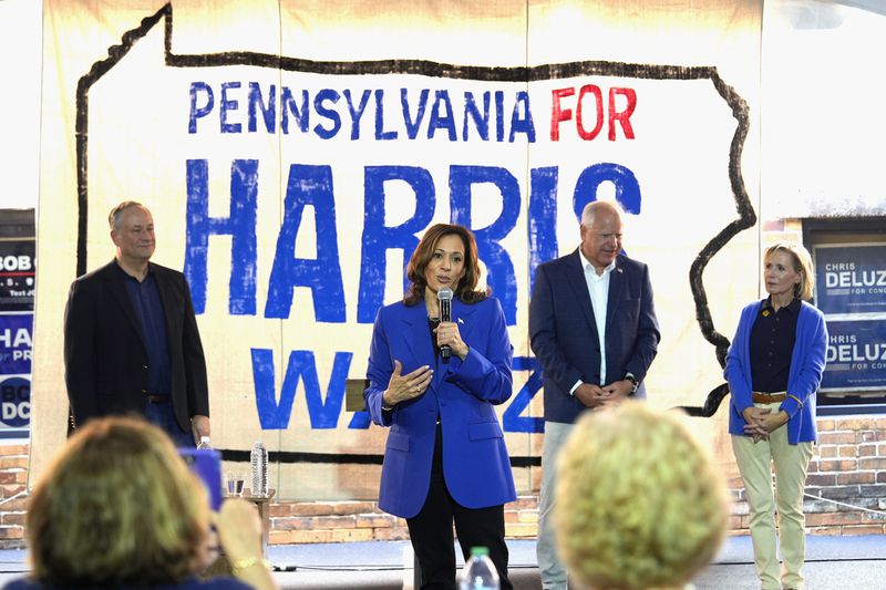 FILE - Democratic presidential nominee Vice President Kamala Harris speaks as second gentleman Doug Emhoff, from left, Democratic vice presidential nominee Minnesota Gov. Tim Walz and his wife Gwen Walz listen at a campaign event, Aug. 18, 2024, in Rochester, Pa. (AP Photo/Julia Nikhinson)