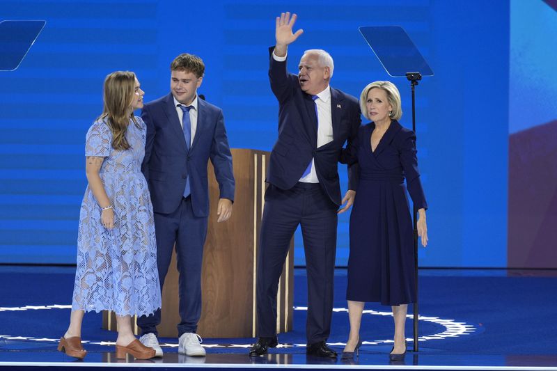 Democratic vice presidential nominee Minnesota Gov. Tim Walz, second from right, poses with his wife Gwen Walz, from right, son Gus Walz and daughter Hope Walz after speaking during the Democratic National Convention Wednesday, Aug. 21, 2024, in Chicago. (AP Photo/J. Scott Applewhite)