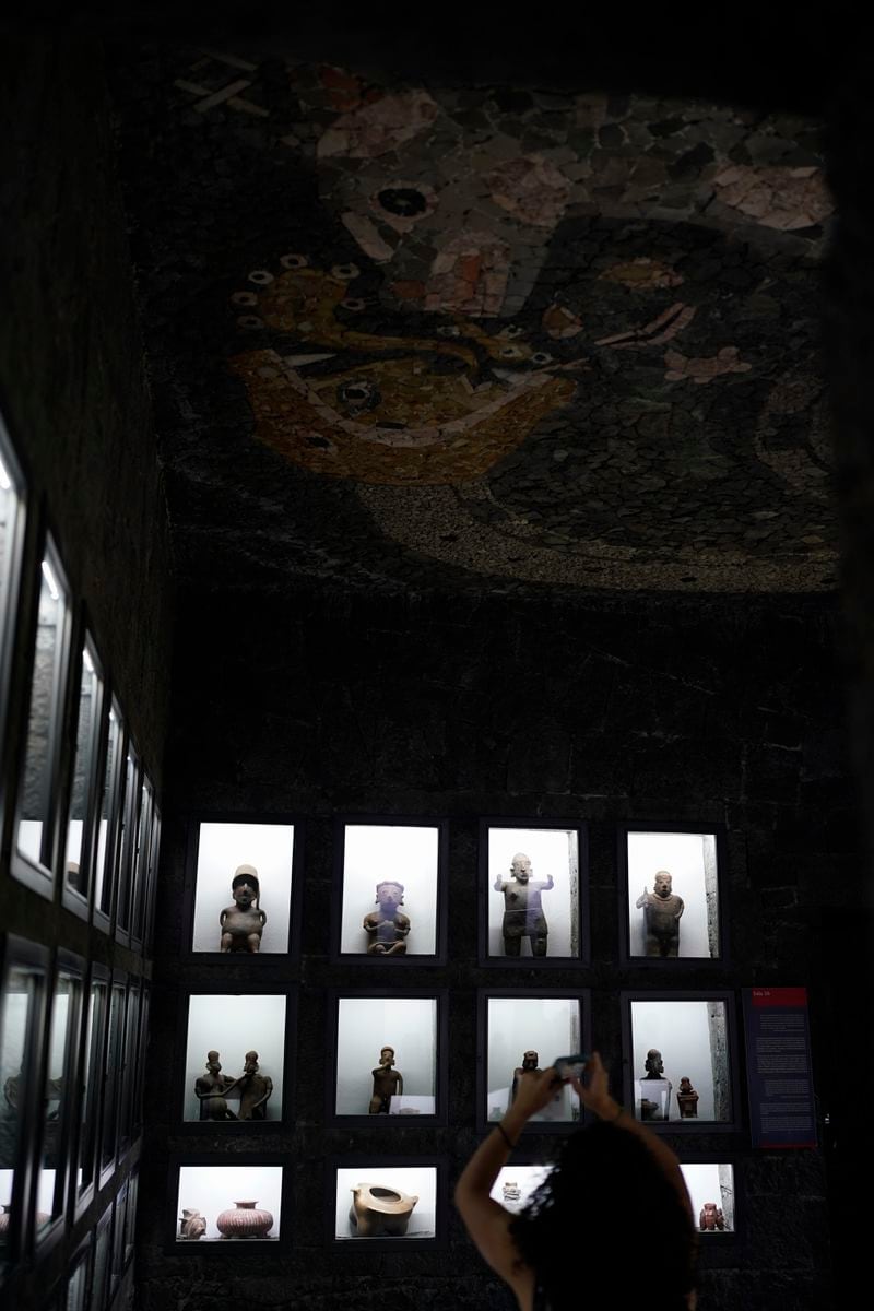 A visitor takes a photo of a ceiling mosaic in the Anahuacalli Museum in Mexico City, Tuesday, Aug. 20, 2024. Built by Mexican artist Diego Rivera to preserve and display his lifelong collection of pre-Hispanic art, the museum is celebrating its 60th anniversary. (AP Photo/Eduardo Verdugo)