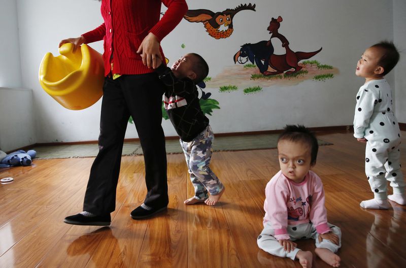 FILE - Children rest and play at a foster home of the New Hope Foundation on the outskirts of Beijing, China, on Oct. 11, 2017. (AP Photo/Ng Han Guan, File)