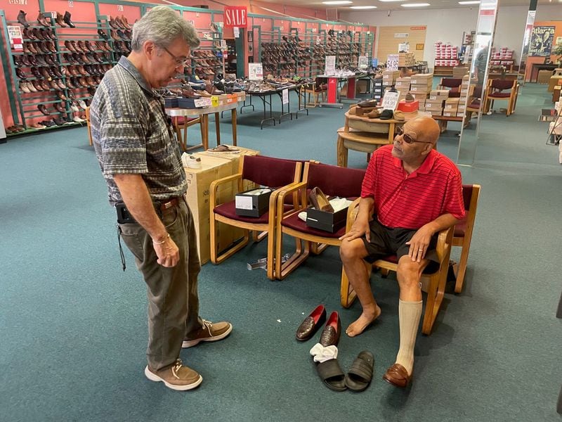 Longtime customer Bob James talks to Bennie's Shoes store manager about a pair of crocodile shoes.