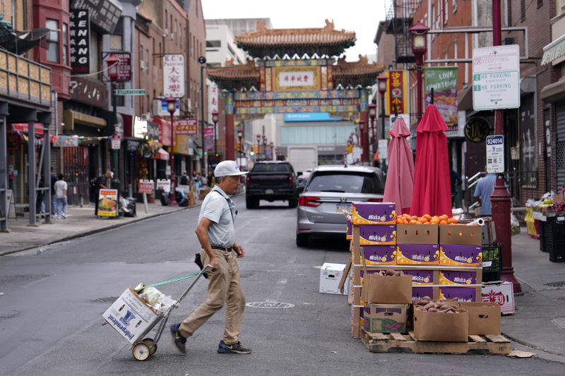 A man walks through the Chinatown neighborhood of Philadelphia, Wednesday, Sept. 18, 2024. (AP Photo/Matt Slocum)