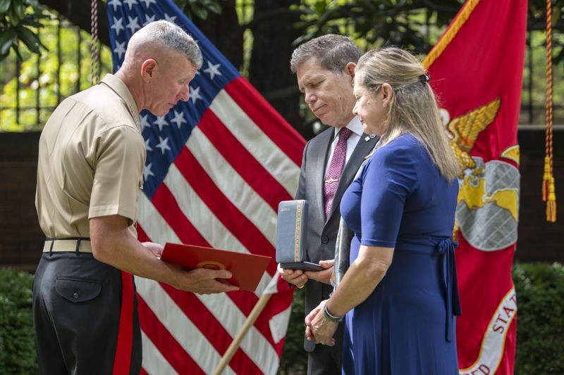 Commandant of the Marine Corps Gen. Eric Smith, left, presents a the Navy and Marine Corps Medal and citation to the parents of Cpl. Spencer Collart, Alexia and Bart Collart during a ceremony on Monday, Sept. 16, 2024 in Washington. (AP Photo/Kevin Wolf)