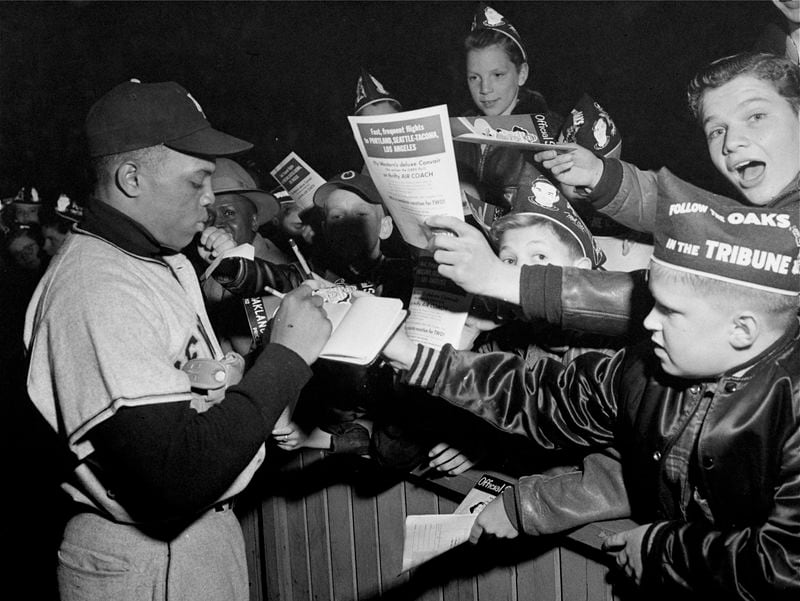 FILE - New York Giants center fielder Willie Mays signs autographs at an exhibition baseball game in Oakland, Calif., in March 1952. Mays, the electrifying “Say Hey Kid” whose singular combination of talent, drive and exuberance made him one of baseball’s greatest and most beloved players, has died. He was 93. Mays' family and the San Francisco Giants jointly announced Tuesday night, June 18, 2024, he had “passed away peacefully” Tuesday afternoon surrounded by loved ones. (AP Photo/File)