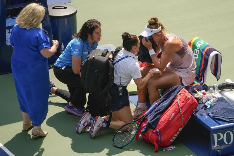 Beatriz Haddad Maia, of Brazil, is checked by medical personnel during the second set against Karolina Muchova, of the Czech Republic, during the quarterfinals of the U.S. Open tennis championships, Wednesday, Sept. 4, 2024, in New York. (AP Photo/Kirsty Wigglesworth)