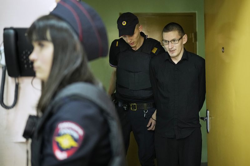 Robert Woodland, right, a Russia-born U.S. citizen, is escorted to the courtroom for a hearing, Thursday, July 4, 2024, in Moscow, Russia. Woodland was convicted of drug-related charges and sentenced to 12 and a 1/2 years in prison on Thursday. (AP Photo/Alexander Zemlianichenko)