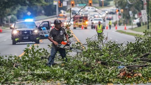 Workers clean up fallen tree on Roswell Road north of Dalrymple after Hurricane Idalia hits Georgia.