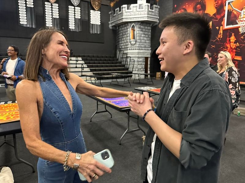 Theresa "T-Bird" Cooper, a flight attendant, competed in "Survivor" season 3 and came again to Ron Clark's "Survivor" party April 12, 2023 at Ron Clark Academy. Here, a 19-year-old "Survivor" fan Philip Tang meets her. RODNEY HO/rho@ajc.com