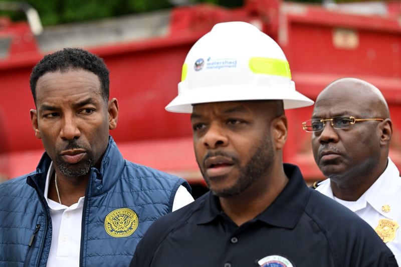 Al Wiggins, Jr., Commissioner of Department of Watershed Management, speaks as Mayor Andre Dickens (left) looks during a press briefing at Joseph E. Boone Boulevard and James P. Brawley Drive, Saturday, June 1, 2024, in Atlanta. A water main that ruptured, causing tens of thousands to lose access to water around Atlanta, was repaired Saturday morning but water may take several hours to be restored. (Hyosub Shin / AJC)