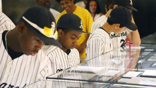 Jahli Hendricks (from left), Nasir Jackson and Jack Rice of the Philadelphia-based Anderson Monarchs look over some of the King papers at the National Center for Civil and Human Rights. The center marked its first anniversary last week. BOB ANDRES / BANDRES@AJC.COM