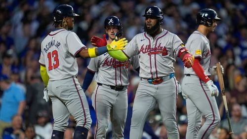 Atlanta Braves designated hitter Marcell Ozuna, right, high-fives Ronald Acuña Jr. after hitting a three-run home run during the seventh inning of a baseball game against the Chicago Cubs, Wednesday, May 22, 2024, in Chicago. (AP Photo/Erin Hooley)