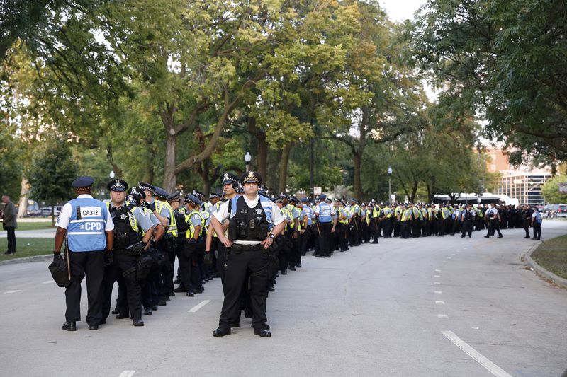 Police officers stand in a line after a March on DNC protest on Monday, Aug. 19, 2024, in Chicago, on standby as they waited for pro-Palestinian protesters to leave Union Park after a two-mile protest march. (AP Photo/Martha Irvine)