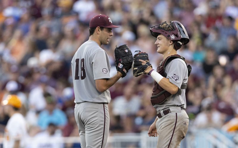 Texas A&M starting pitcher Ryan Prager, left, chats with catcher Jackson Appel before leaving the mound against Tennessee in the fifth inning of Game 1 of the NCAA College World Series baseball finals in Omaha, Neb., Saturday, June 22, 2024. (AP Photo/Rebecca S. Gratz)