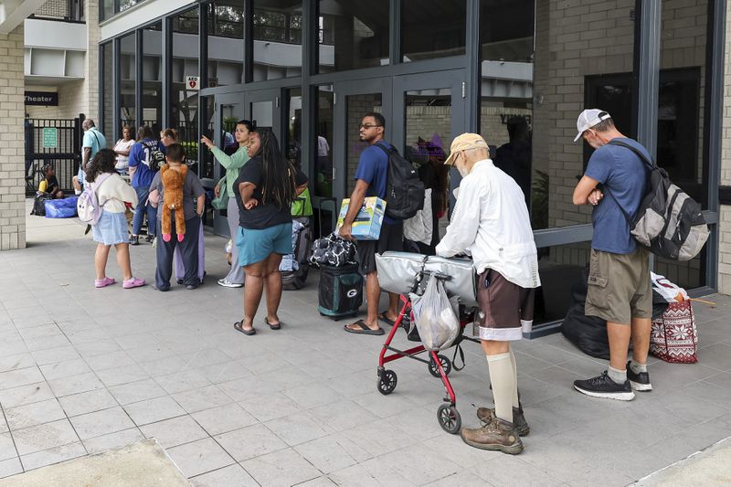 Pasco County evacuees await the opening of the shelter at River Ridge High School in preparation for Hurricane Milton on Monday, Oct. 7, 2024, in New Port Richey, Fla. (AP Photo/Mike Carlson)