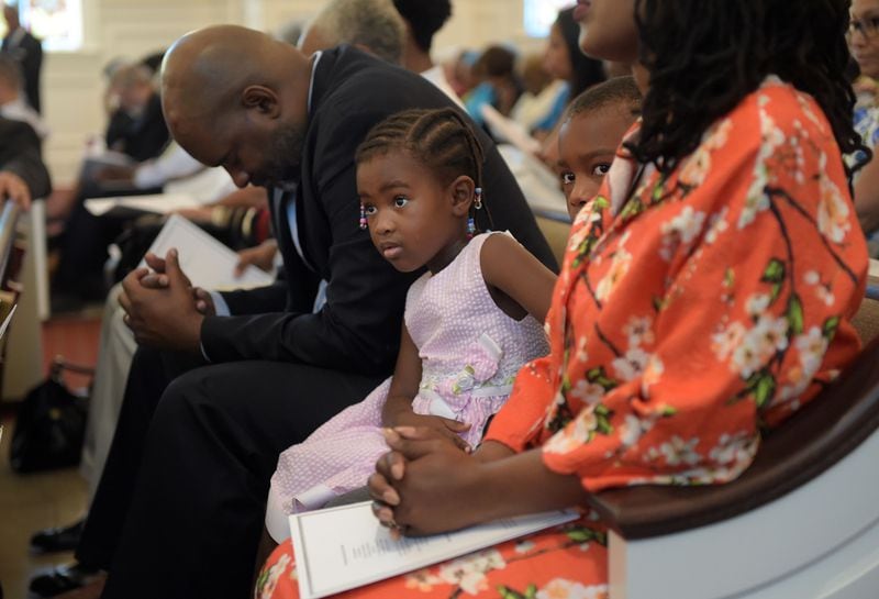 Hapibah Jones, 4, and her brother, Kojo, 7, sit with their parents, Agai and Vuyani Jones, as they attend the first morning worship service at Friendship Baptist Church Sunday, July 30, 2017. KENT D. JOHNSON / AJC