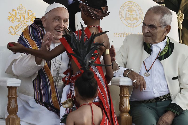 Pope Francis greets youths in traditional dress as East Timor's President Jose Ramos-Horta looks on during a welcoming ceremony at the Presidential Palace in Dili, East Timor, Monday Sept. 9, 2024. In East Timor Francis had to negotiate perhaps the most sensitive issue clouding the visit to Asia and Oceania : the case of Bishop Carlos Ximenes Belo, the revered national hero who won the Nobel Peace Prize for his nonviolent independence campaign. (Yasuyoshi Chiba/Pool Photo via AP)