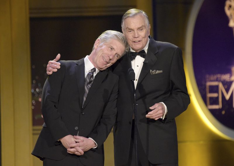 FILE - Tom Bergeron, left, rests his head on Peter Marshall's shoulder as they present an award at the 45th annual Daytime Emmy Awards in Pasadena, Calif., on April 29, 2018. Marshall, who spent 16 years as host of “The Hollywood Squares,” has died at 98. (Photo by Richard Shotwell/Invision/AP, File)