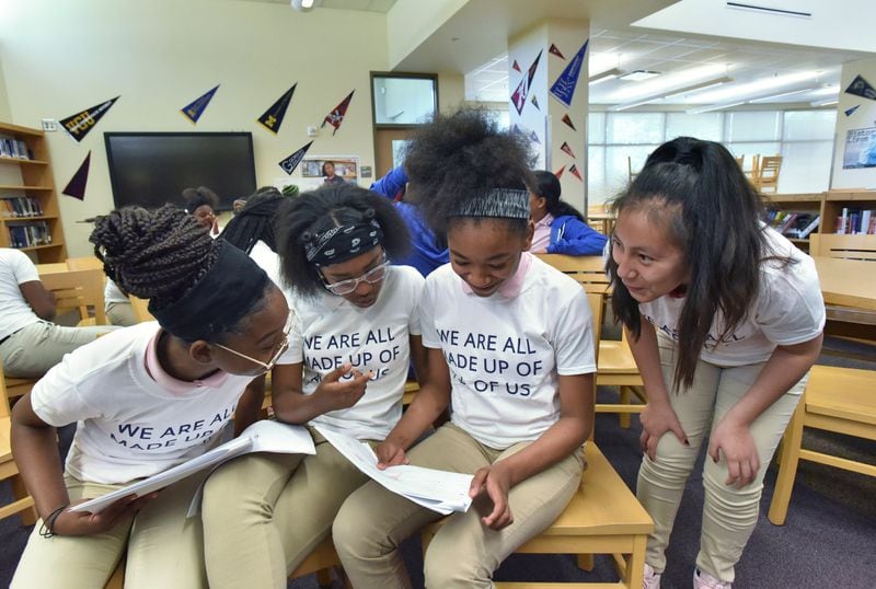 Students (from left) Za’Keijah Davis, 13, Taleya Pemberton,12, Jahmya Phillips, 13, and Elianed Guzman, 13, react after they learned the results of their DNA tests at Coretta Scott King Young Women’s Leadership Academy. The event marked the end of their seventh grade life sciences unit in which they studied a range of topics from genotyping to colorism. HYOSUB SHIN / HSHIN@AJC.COM