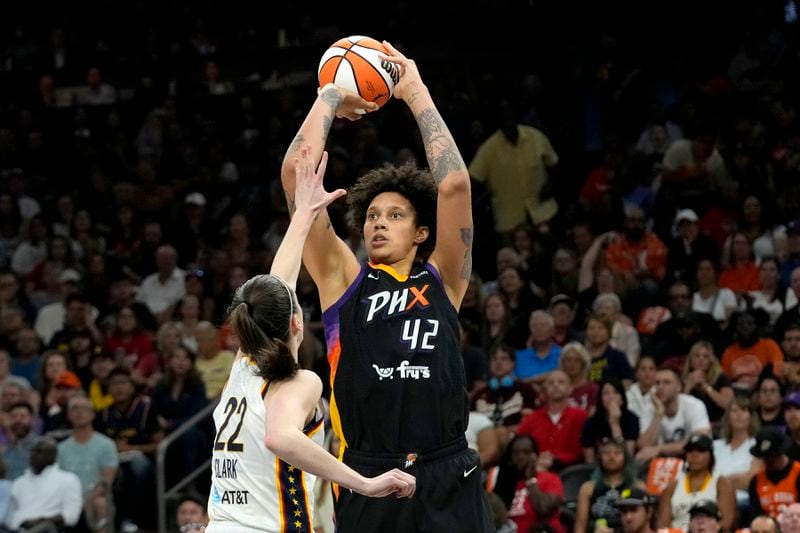 Phoenix Mercury center Brittney Griner (42) looks to shoot over Indiana Fever guard Caitlin Clark (22) during the second half of a WNBA basketball game Sunday, June 30, 2024, in Phoenix. (AP Photo/Ross D. Franklin)