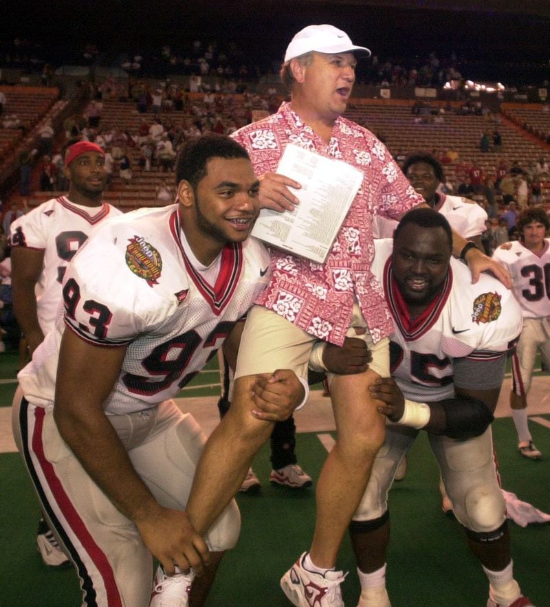 001224-HONOLULU-Richard Seymour (cq) (lft) and Jonas Jennings (cq) lift Jim Donnan onto their shoulders after the Bulldogs' win against Virginia at the Oahu Bowl Sunday, December 24, 2000 at the Aloha Stadium.This is Donnan's last game coaching the Bulldogs, due to a recent firing. (T. LEVETTE BAGWELL/AJC STAFF)