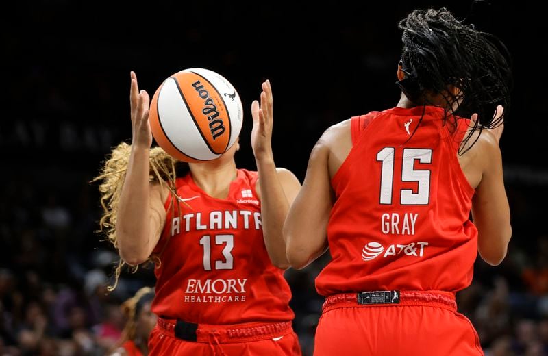 Atlanta Dream guard Haley Jones (13) makes a rebound by teammate Allisha Gray (15) during the first half of an WNBA basketball game against the Las Vegas Aces Friday, Aug. 30, 2024 in Las Vegas. (Steve Marcus/Las Vegas Sun via AP)