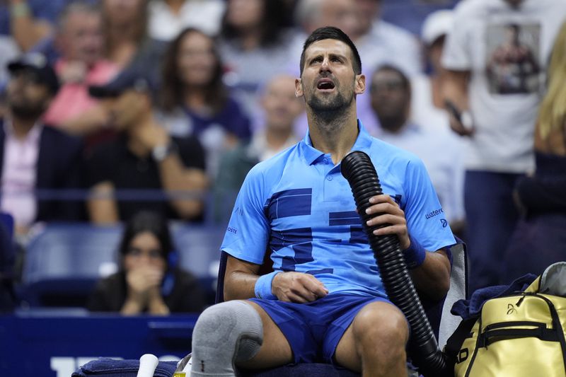 Novak Djokovic, of Serbia, tries to stay cool during a third round match against Alexei Popyrin, of Australia, of the U.S. Open tennis championships, Friday, Aug. 30, 2024, in New York. (AP Photo/Julia Nikhinson)