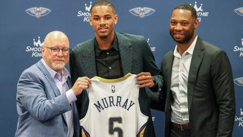 New Orleans Pelicans new player Dejounte Murray, center, joined by Pelicans Executive Vice President of Basketball Operations David Griffin, left, and head coach Willie Green pose during an NBA basketball news conference Tuesday, July 9, 2024, in New Orleans. (Sophia Germer/The Times-Picayune/The New Orleans Advocate via AP)