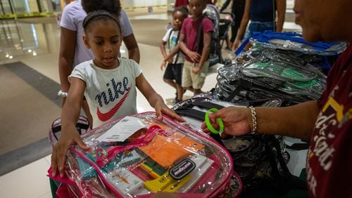 Makayla Smith receives a free school supply kit and clear backpack at the 20th annual Back-to-School Bash at Greenbriar Mall in Atlanta on Saturday, July 22, 2023. (Katelyn Myrick/AJC)