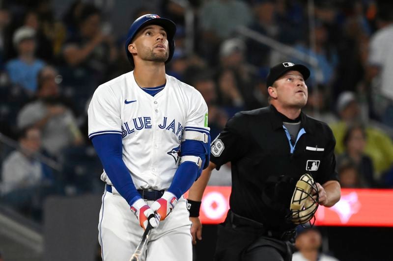 Toronto Blue Jays' George Springer, left, and home plate umpire Sean Barber, right, watch as Springer's hit drifts foul during the sixth inning of a baseball game against the Philadelphia Phillies in Toronto on Tuesday Sept. 3, 2024. (Jon Blacker/The Canadian Press via AP)