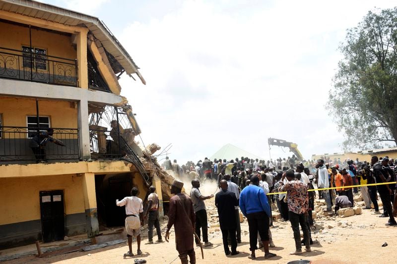 People gather at the scene of a collapsed two-storey building in Jos, Nigeria, Friday, July, 12, 2024. At least 12 students have been killed after a school building collapsed and trapped them in northern Nigeria, authorities said on Friday. (AP Photos)