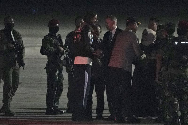 The New Zealand pilot who was held hostage for more than a year by separatist rebels in the Papua region, Phillip Mark Mehrtens, center, is greeted by New Zealand Ambassador to Indonesia Kevin Burnett and Indonesian officials upon arrival at Halim Perdanakusuma Air Base in Jakarta, Indonesia, Saturday, Sept. 21, 2024. (AP Photo/Achmad Ibrahim)