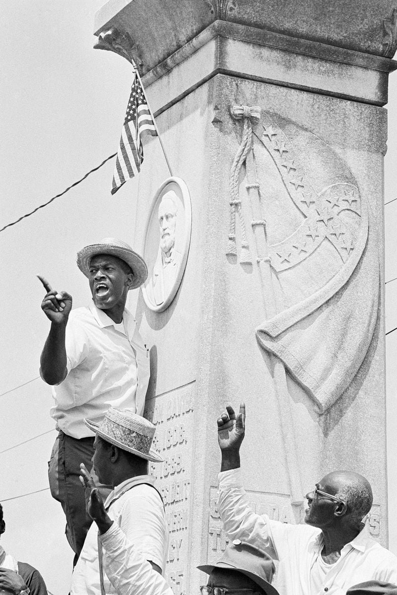 FILE - Robert Green, a leader in the Southern Christian Leadership Conference, speaks from the Confederate Memorial statue in the Grenada town square in Mississippi, June 14, 1966, after planting an American Flag above the bas relief of Confererate President Jefferson Davis. (AP Photo, File)