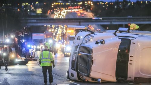 March 12, 2018 Gwinnett County: Several drivers from Willard Wrecker Service work to right-side a tractor-trailer hauling 41,000 pounds of cheese that overturned on Ga. 20 near the Mall of Georgia, snarling traffic at the height of the morning commute on Monday March 12, 2018. The truck, a Khushi Freight Carrier, was coming off the I-85 ramp onto eastbound Ga. 20 when it overturned. Officers were dispatched to the scene just before 6:10 a.m. Lanes did not reopen until just before 8:45 a.m. According to police, the driver faces a charge of driving too fast for conditions. The driver has not been identified. The accident was the second major crash of the morning in Gwinnett County. A deadly crash temporarily blocked multiple lanes of I-85 North just north of Old Peachtree Road. Details about that crash have not been released. JOHN SPINK/JSPINK@AJC.COM