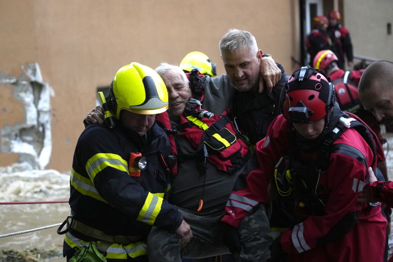 A resident is evacuated from his flooded house in Jesenik, Czech Republic, Sunday, Sept. 15, 2024. (AP Photo/Petr David Josek)