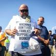 Longshoremen bow for a prayer during a strike at the Bayport Container Terminal on Tuesday, Oct. 1, 2024, in Houston. (AP Photo/Annie Mulligan)