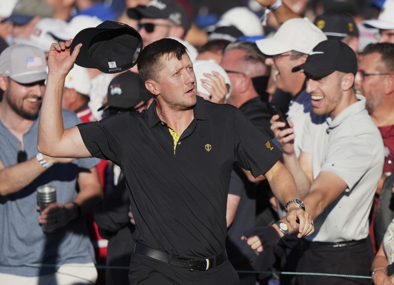 International team member Mackenzie Hughes of Canada, pumps up the crowd on the 16th hole during second round foursome match at the Presidents Cup golf tournament at Royal Montreal Golf Club Friday, September 27, 2024 in Montreal. (Nathan Denette/The Canadian Press via AP)