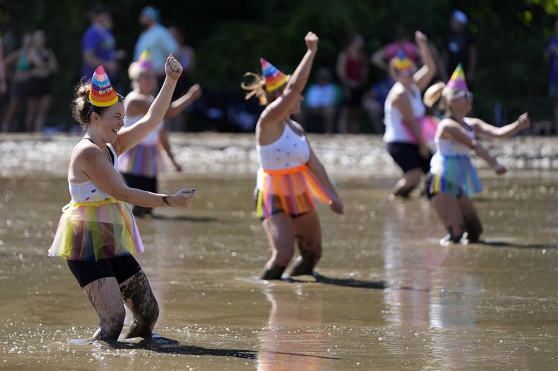 Tori Belkin, foreground, and the Hogettes, entertain the crowd in between football games at the Mud Bowl competition in North Conway, N.H., Saturday, Sept. 7, 3024. (AP Photo/Robert F. Bukaty)