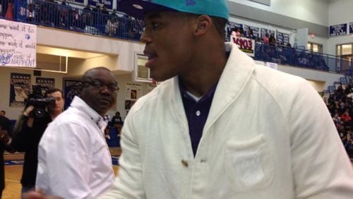 Carolina Panthers quarterback Cam Newton shakes hands with the official scorer before his jersey was retired at Westlake High on Friday night.