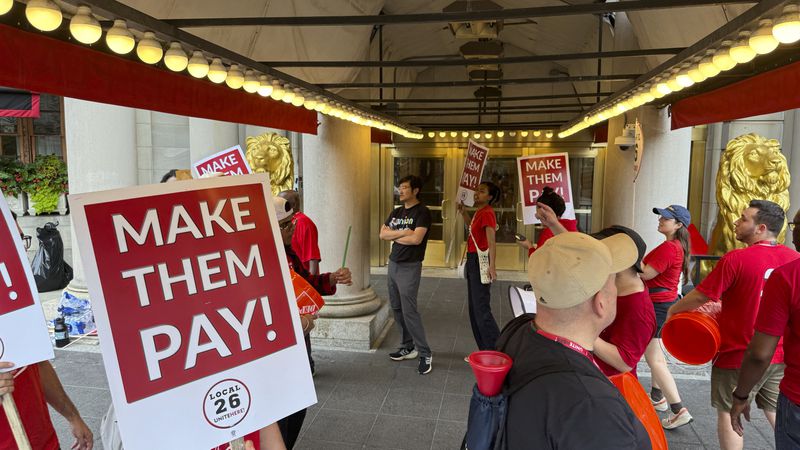 Hotel workers on strike chant and beat drums while picketing outside the Fairmont Copley Plaza hotel on Sunday, Sept. 1, 2024, in Boston. (AP Photo/Rodrique Ngowi)