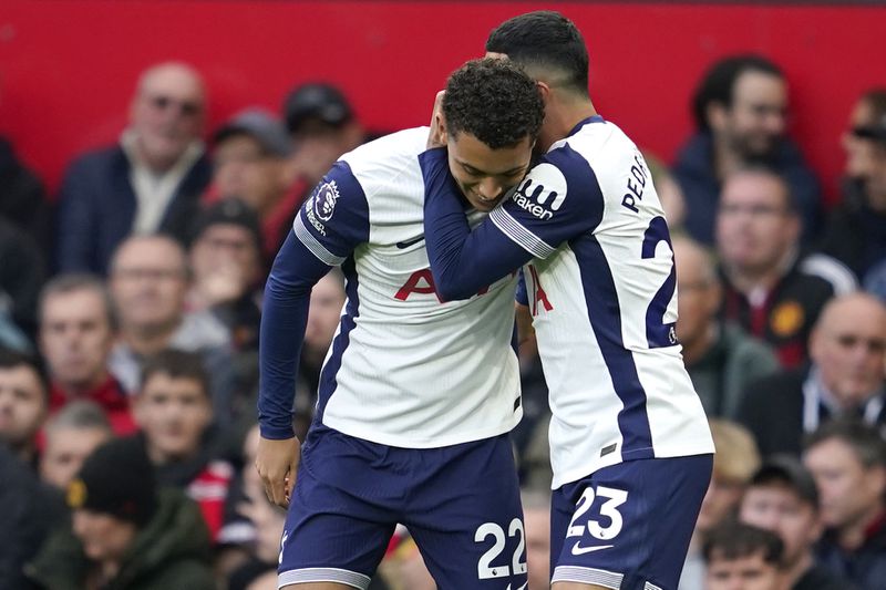 Tottenham's Brennan Johnson, left, celebrates after scoring his side's opening goal during the English Premier League soccer match between Manchester United and Tottenham Hotspur at Old Trafford stadium in Manchester, England, Sunday, Sept. 29, 2024. (AP Photo/Dave Thompson)