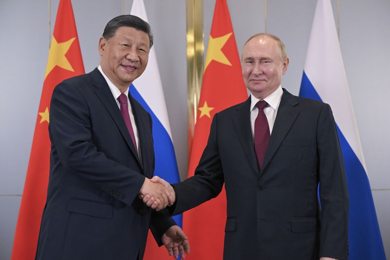 Russian President Vladimir Putin, right, and Chinese President Xi Jinping shake hands as they pose for photos during their meeting on the sidelines of the Shanghai Cooperation Organisation (SCO) summit in Astana, Kazakhstan, Wednesday, July 3, 2024. (Sergey Guneyev, Sputnik, Kremlin Pool Photo via AP)